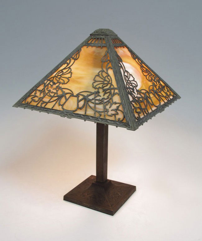 VINTAGE SLAG GLASS TABLE LAMP: VINTAGE SLAG GLASS TABLE LAMP: Conical 4 panel shade of caramel slag glass panels under metal filigree. Embossed iron base, bronzed metal stem. Double socket, turn on switch in the wire. 20" tall x 13