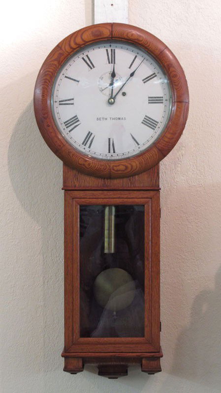 SETH THOMAS NO.2 REGULATOR WALL CLOCK: SETH THOMAS NO.2 REGULATOR WALL CLOCK: Golden oak case, painted metal face with Roman numerals. Marked Seth Thomas on face. Key in office, pendulum in case. 35" h. x 15 1/2" x 5 1/4".