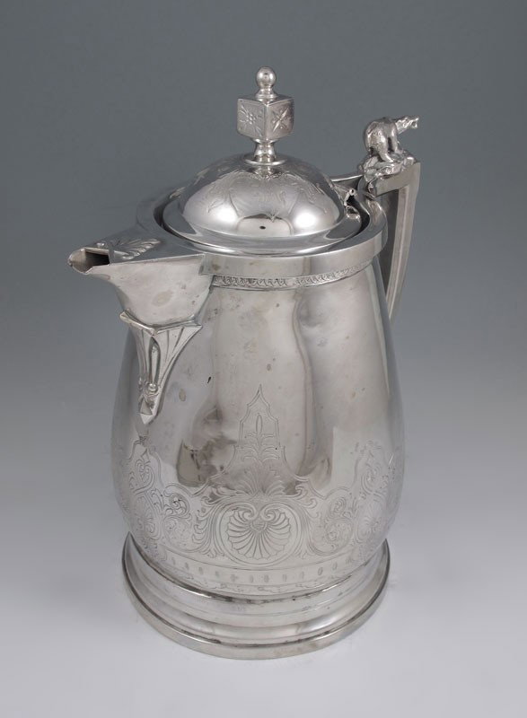 JAMES STIMPSON VICTORIAN SILVERPLATE WATER PITCHER: JAMES STIMPSON VICTORIAN SILVERPLATE WATER PITCHER: Large pitcher with engraved deigns, hinged lid and unique bear finial on handle. Marked James Stimpson on base with last patent date of 1868. 13" h.