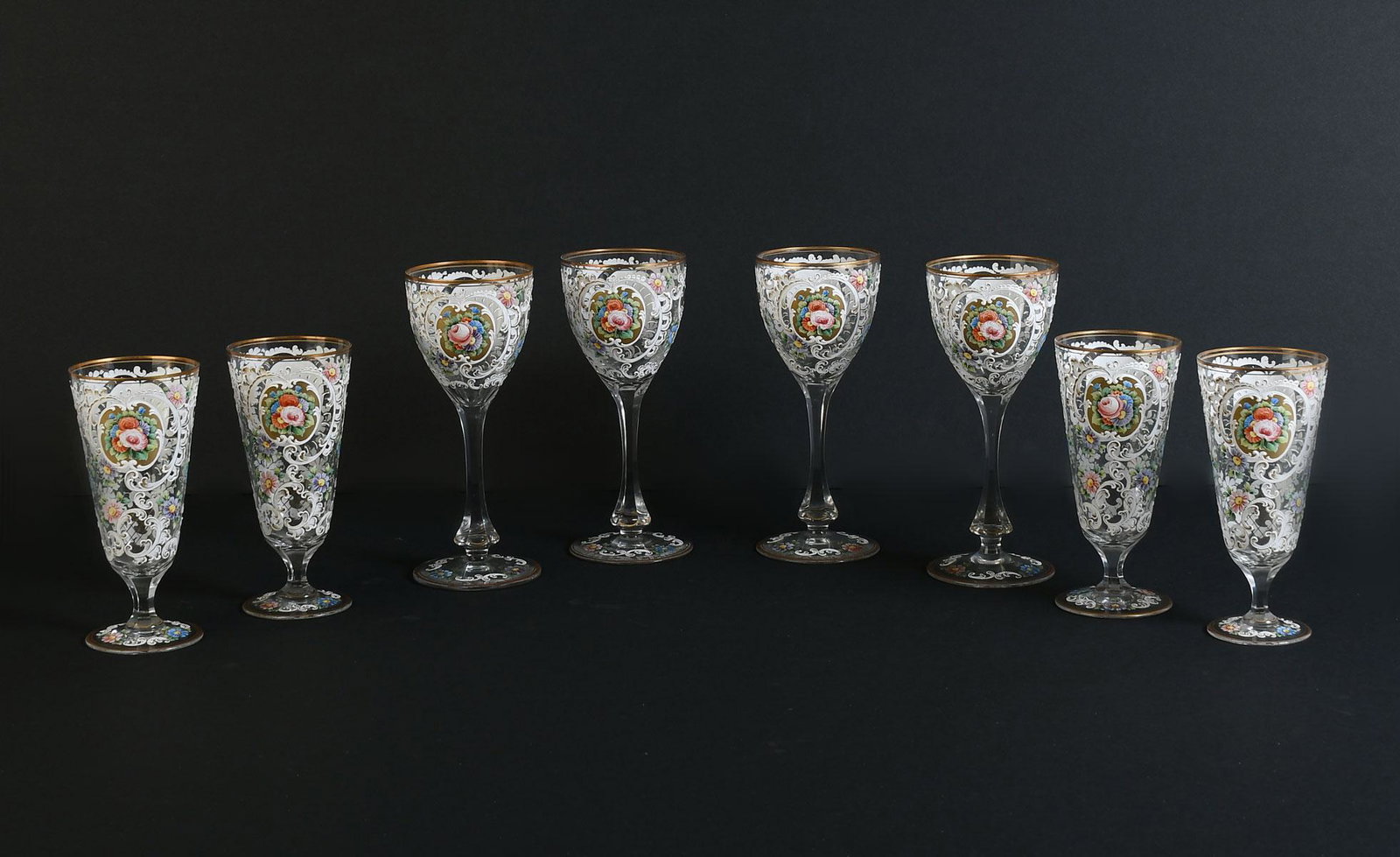 8 PC. FRENCH ENAMELED STEMS: 8 PC. FRENCH ENAMELED STEMS: Comprising; 4- Wine glasses, & 4- Pilsner glasses. All having a raised enameled scrolling foliate motif with floral medallions. Wine glasses Approx. 8.25'' h x 3.5'' w. Pi