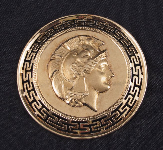 18K GOLD GRECIAN MEDALLION BROOCH 10.4 GRAMS: 18K GRECIAN MEDALLION BROOCH: 18K yellow gold medallion with a Repoussé Grecian warrior on front. Greek Key cut out design on frame. Bar pin closure. Weight: 10.4 grams. 1 1/4'' in diameter.