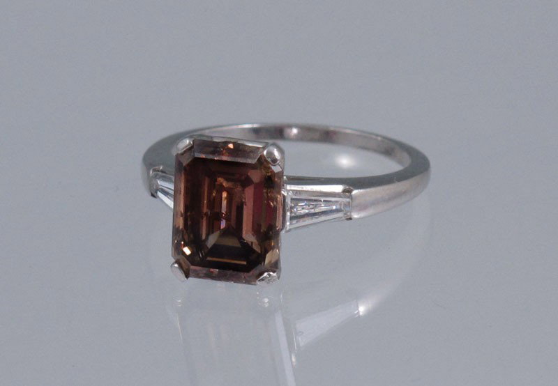 PLATINUM 3.41 COGNAC DIAMOND SOLITAIRE: PLATINUM 3.41 CT SOLITAIRE COGNAC DIAMOND RING WITH NEAR COLORLESS BAGUETTES: Platinum ring contains one emerald cut diamond. Weight: 3.41 Ct. Approx. Rated I1 in clarity and Fancy Light Brown (C-6) i