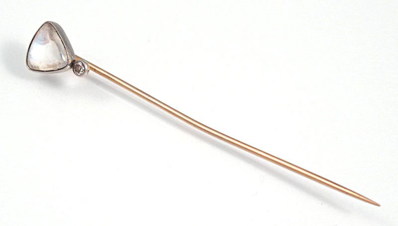 1920'S PLATINUM AND GOLD MOONSTONE STICK PIN: PLATINUM AND GOLD MOONSTONE STICK PIN: Ca, 1920. 18K yellow gold and platinum stick pin has a 1 Ct triangle shaped cabochon cut moon stone and 1 old European round cut diamond. The diamond is approx.