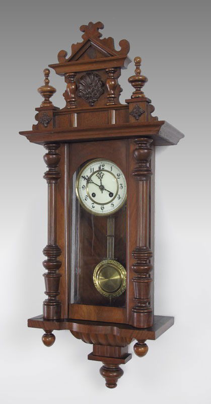 KIENZLE REGULATOR CARVED WALL CLOCK: KIENZLE REGULATOR CARVED WALL CLOCK: Ornate German black forest carving, key and pendulum movement marked with Kienzle spoked wheel and wings logo. Original key in office. 36'' h. x 14 1/2'' x 7 1/2''