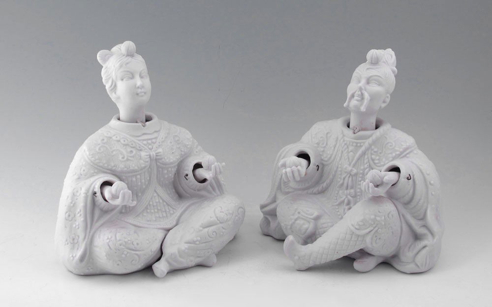 PAIR OF BISQUE NODDERS: PAIR OF BISQUE NODDERS: Japanese figures, man and woman holding fruit. Nodding head and hands. 7 1/8" h. x 6 1/2" x 6".