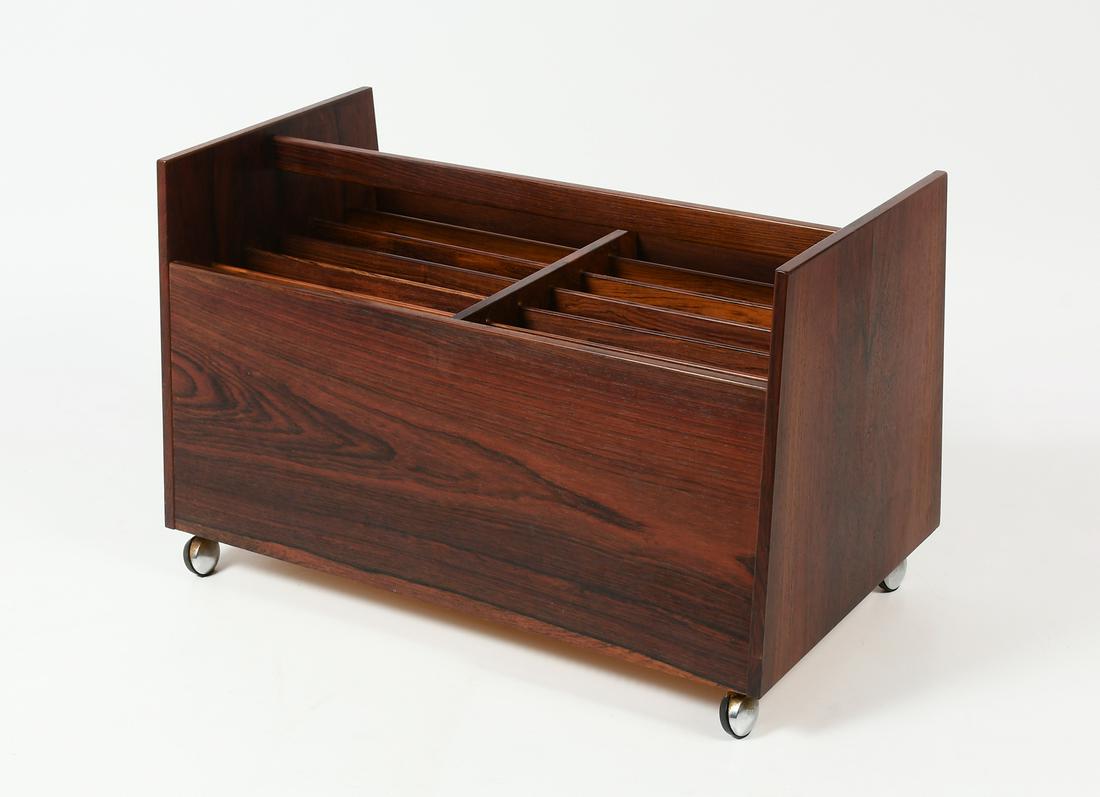 MID-CENTURY MODERN ROSEWOOD MAGAZINE RACK: MID-CENTURY MODERN ROSEWOOD MAGAZINE RACK: Norwegian Mid Century magazine rack, by Bruksbo, Bagn Mobelindustri. MCM canterbury on Casters. Approx. 17.25'' h x 26.75'' l x 15.75'' w.