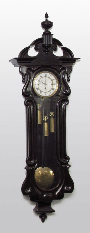 SERPENTINE TRIPLE WEIGHT VIENNA REGULATOR WALL CLOCK: SERPENTINE TRIPLE WEIGHT VIENNA REGULATOR WALL CLOCK: Architectural carved pediment with urn finial over serpentine form case. Illegible dealers name on face. Porcelain dial with Roman numerals, tripl