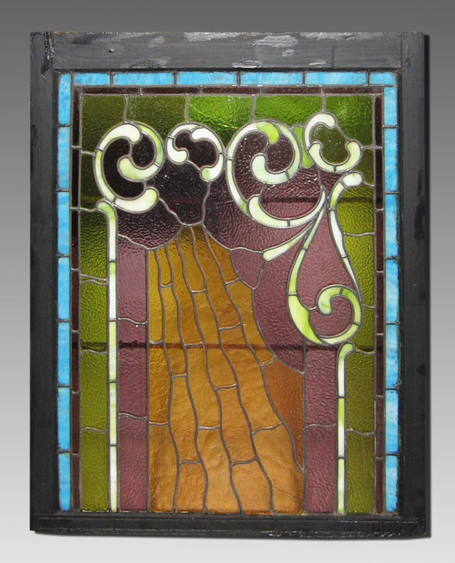 LEADED STAINED GLASS WINDOW: LEADED STAINED GLASS WINDOW: Art Nouveau design in textured and slag glass. Blue, amber, purple and green. Measurements include the original wood frame, 38" x 30 1/2". Approx. 3 pieces with cracks.