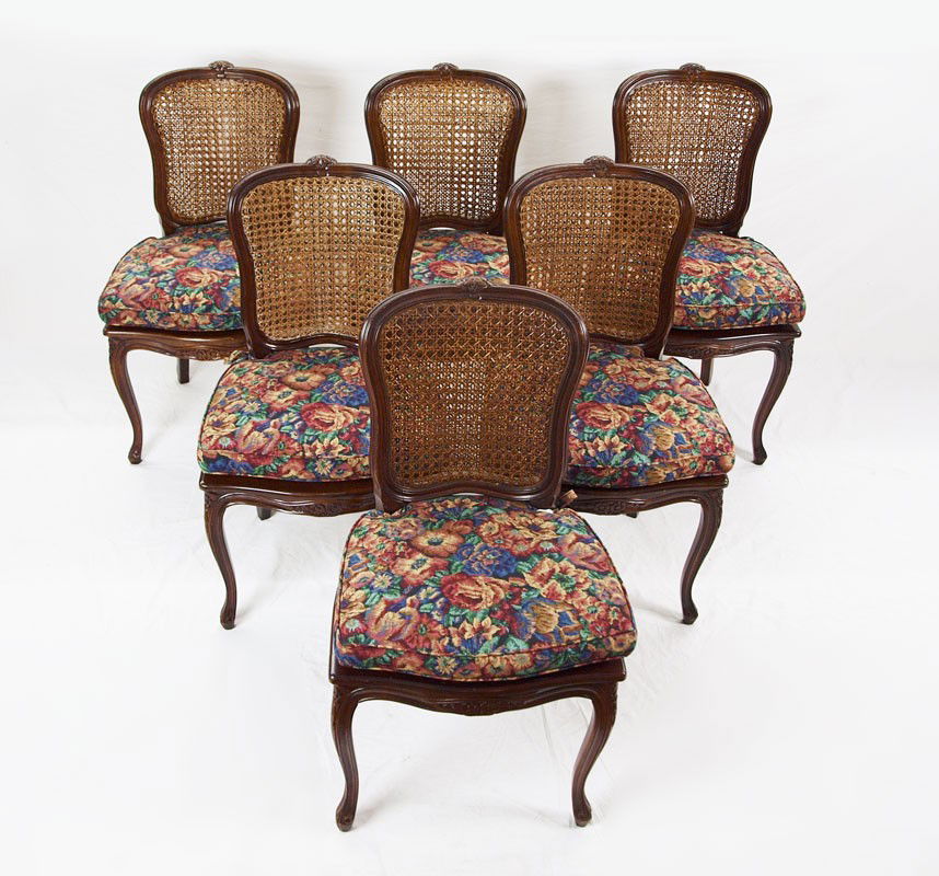 6 CANED FRENCH PROVINCIAL CHAIRS: 6 CANED FRENCH PROVINCIAL CHAIRS: Carved floral decoration on top rail, apron and front legs. Caned backs and seats. Floral cushions. 36 1/2" h. x 21" x 20 1/2".