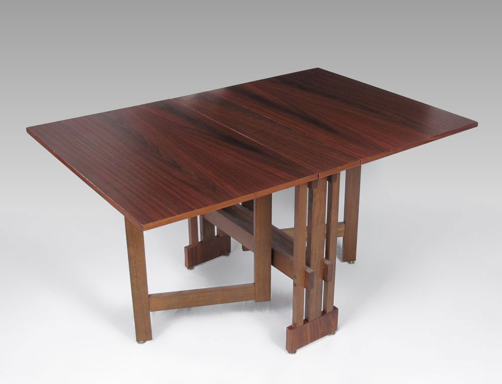 KITTINGER MODERN DESIGN WALNUT TABLE: KITTINGER MODERN DESIGN WALNUT DROP LEAF TABLE: A mere 8 3/4" wide x 36" x 29 1/2" h. Swing legs support the leaves. With leaves raised the table extends to 60"l. Kittinger metal label.