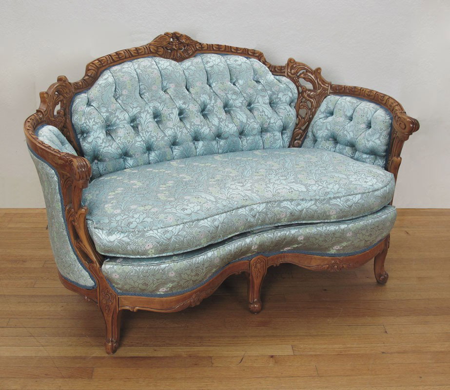DEUTCH BROTHERS CARVED SETTEE: DEUTCH BROTHERS CARVED SETTEE: Profusely carved with figural birds, shaped arm rests and front. Floral blue upholstery. 36" h. x 56" x 33 1/2".