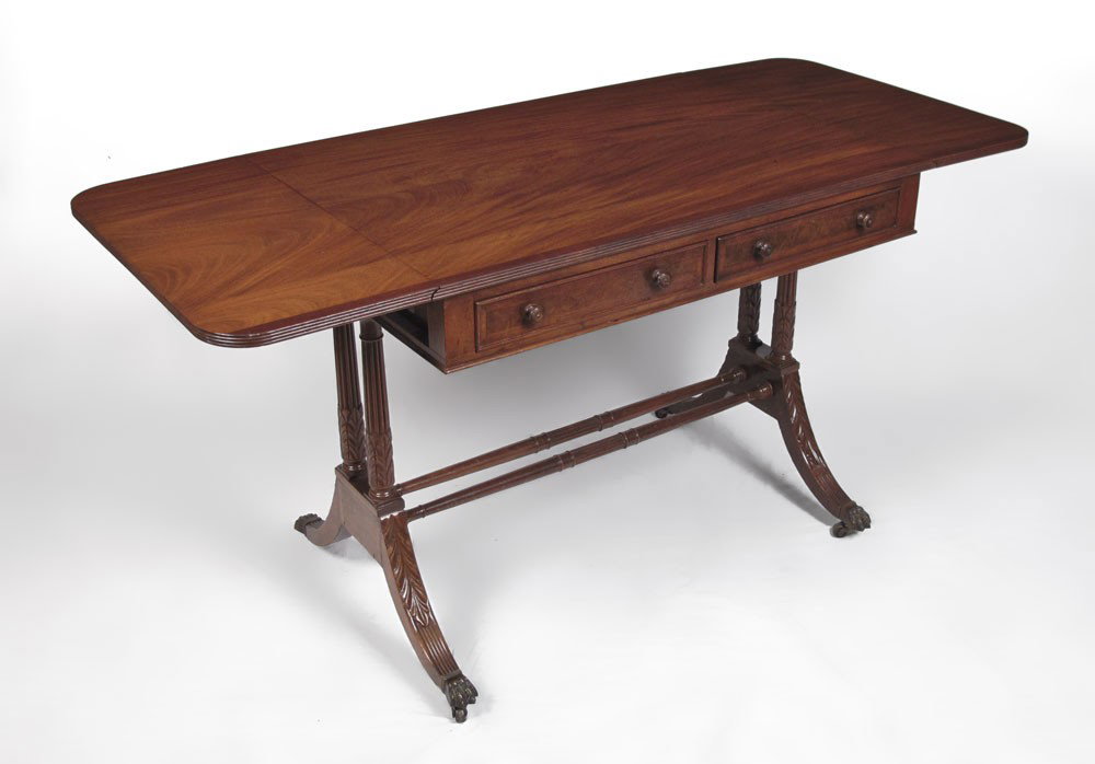 KITTINGER MAHOGANY 2 DRAWER DROP LEAF TABLE: KITTINGER MAHOGANY WRITING TABLE: Two half length drawers, two drop leaves, double pedestal joined by stretchers, splayed legs, brass covered feet on castors. 29 1/2" h. x 37" x 25 1/4".