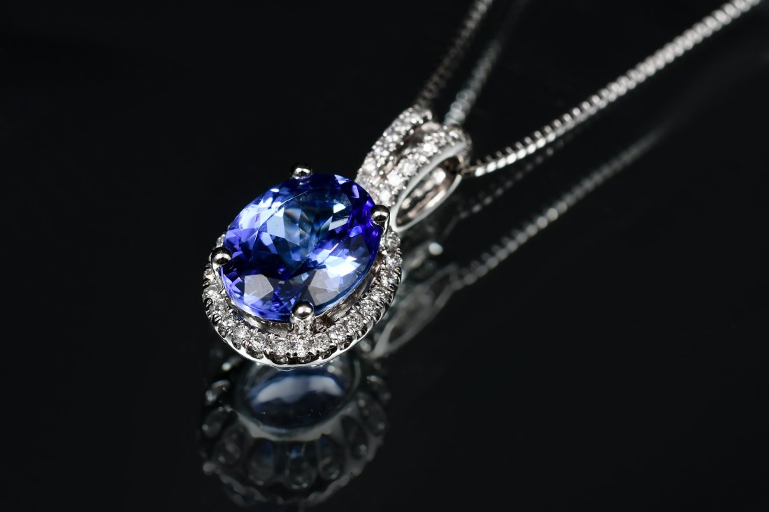 14K TANZANITE & DIAMOND PENDANT: 14K TANZANITE & DIAMOND PENDANT: 14K white gold pendant contains one oval mixed-cut tanzanite. Weight: approx. 3.00 Ct. Rated VVS in clarity (Type I), bV in Hue, 5 in Tone and 3-4 in Saturation. 44 ro