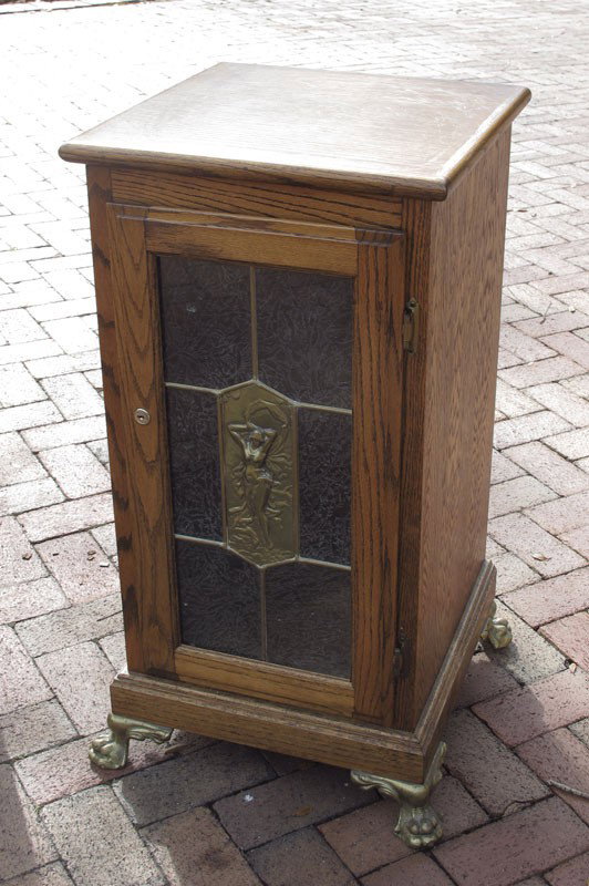 ART NOUVEAU STYLE OAK SLOT MACHINE STAND: ART NOUVEAU STYLE OAK SLOT MACHINE STAND: Oak case with single paneled front door with etched glass designs and center section featuring cast metal Art Nouveau maiden. On 4 cast claw feet. 34 1/4'' h.