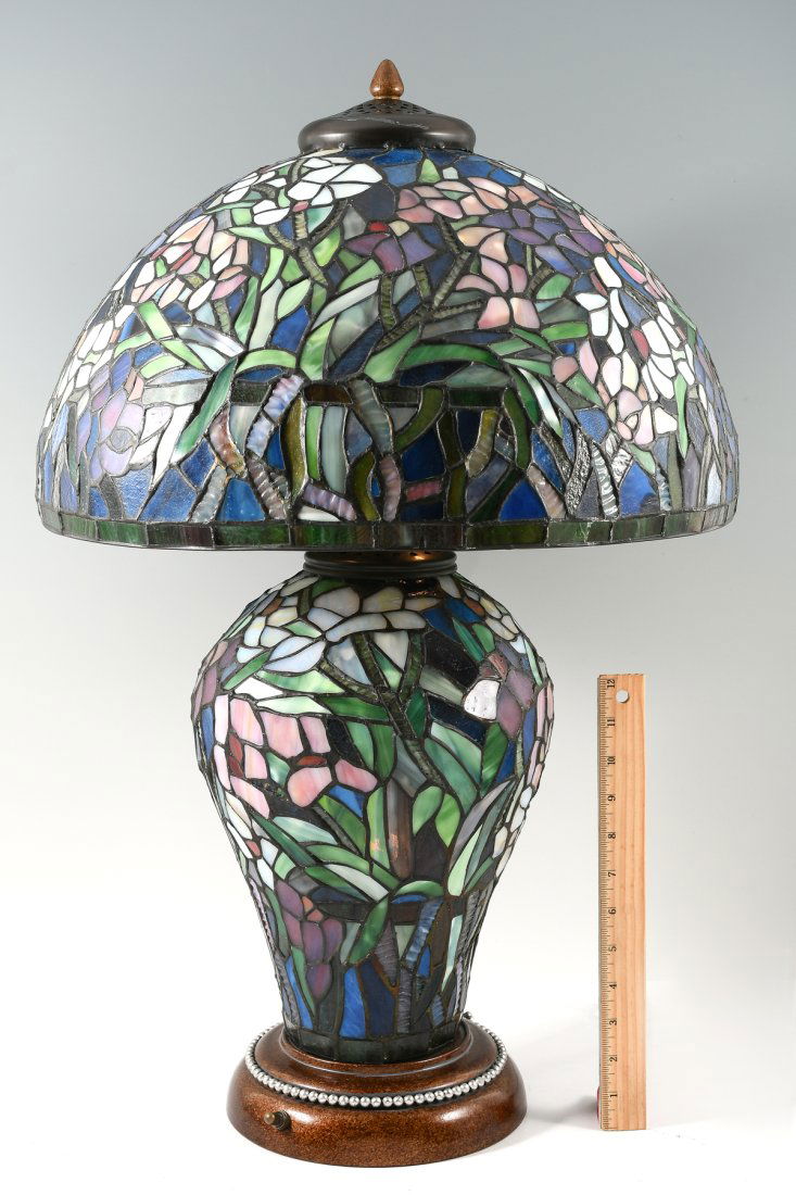 TIFFANY STYLE LEADED GLASS LAMP: TIFFANY STYLE LEADED GLASS LAMP: Three-way stained-glass lamp having an illuminated base supporting a domed shade with vented heat cap and acorn finial. Double bulbs illuminate the highly decorative b