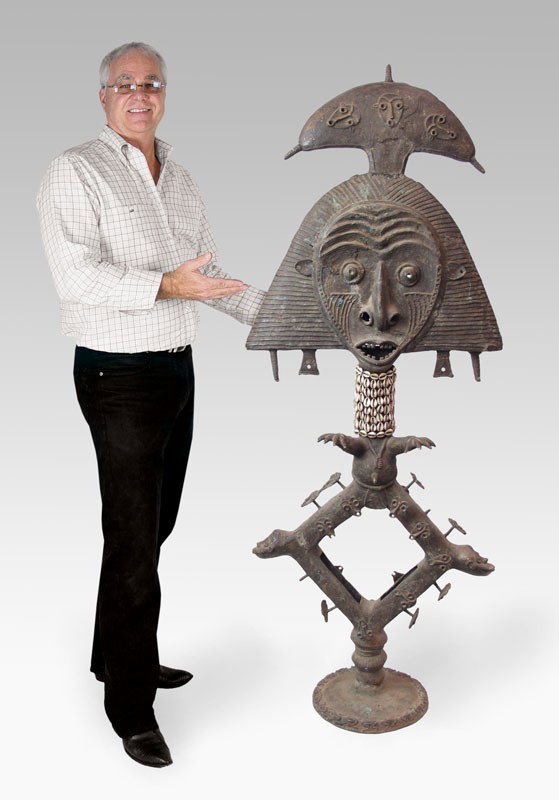 BAKOTA RELIQUARY GUARDIAN FIGURE 68''' TALL: AFRICAN BOKOTA TRIBE RELIQUARY GRAVE GUARDIAN SCULPTURE: "Mbulu ngulu" Metal statue in an abstract geometric form with pegs for hanging fetishes. Cowry shells around his neck. Approx. 68" x 26" x 12".