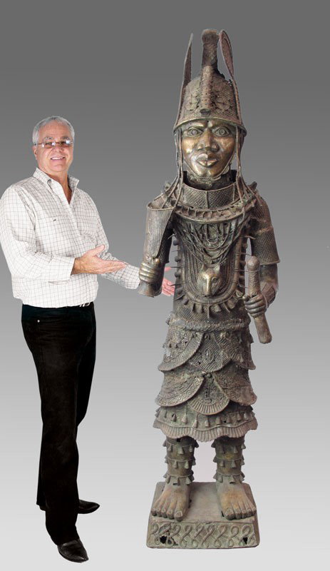 OVER 6 FT TALL BENIN AFRICAN WARRIOR SCULPTURE: AN IMPORTANT BENIN AFRICAN CAST METAL WARRIOR SCULPTURE: Finely detailed and dressed in full. Note the leopard on his chest, a symbol of great importance in the tribe. Measures approx. 6'10" x 20' x 2
