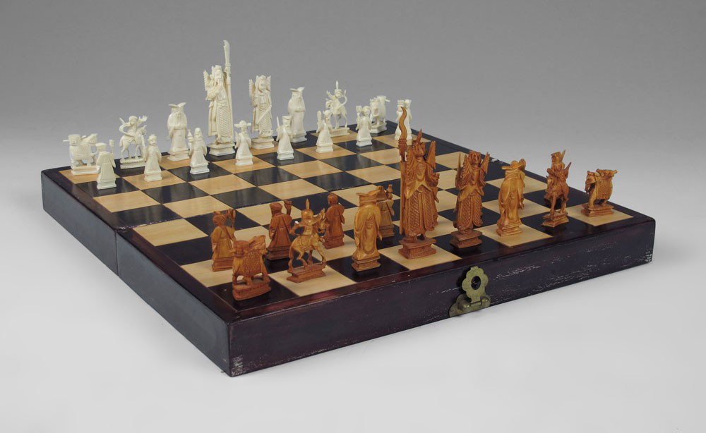 CARVED IVORY CHESS SET IN GAME BOX: CARVED IVORY CHESS SET IN GAME BOX: Chinese carved ivory chess set. Figural pieces representing nobles and the court. Kings measures 4 1/2" h. Sold in wood game board box, measures 3 1/4" h. x 8" x 16