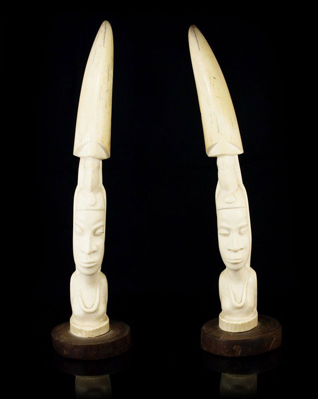 PAIR CARVED AFRICAN IVORY TUSKS 14" tall: PAIR CARVED AFRICAN IVORY TUSKS: Each portrait bust carved from single tusk, approx. 14" tall. Mounted on a .75" wood base.