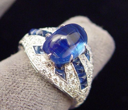 5CT KYANITE 1.3ctw SAPPHIRE .95ctw DIAMOND RING: SPECTACULAR 5CT KYANITE, SAPPHIRE & DIAMOND RING: Featured stone is a 5.14ct domed kyanite stone, with matching smaller domes of sapphires branching off, all on a diamond encrust mount of 18k white go