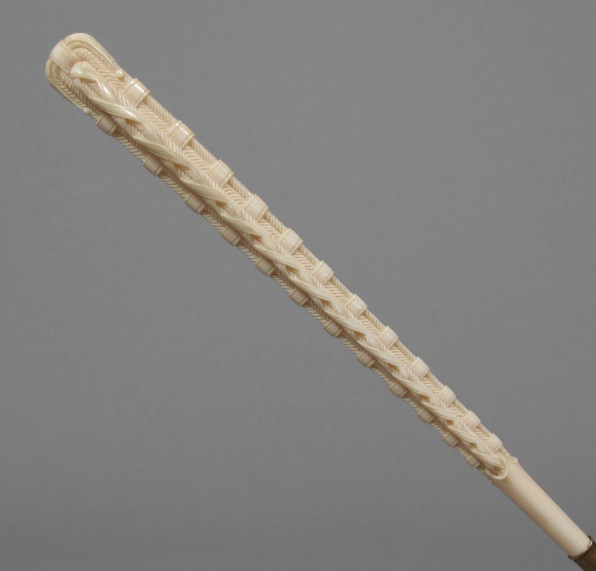 VICTORIAN CARVED IVORY HANDLE PARASOL: VICTORIAN CARVED IVORY HANDLE PARASOL: Folding parasol of black point de gase lace over silk. The ivory handle is carved in a woven geometric pattern. Total length approx. 27''. Handle length 11''.