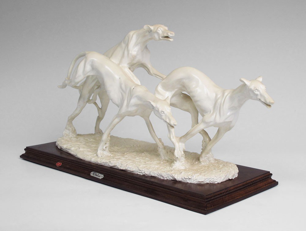 AURO BELCARI CAPODIMONTE SCULPTURE OF GREYHOUNDS: AURO BELCARI CAPODIMONTE SCULPTURE OF GREYHOUNDS: Composite composition, figure of 3 greyhounds racings, affixed to wood base. Original Capodimonte tag. 9 7/8'' h. x 17 3/4'' h. x 6 1/2''.