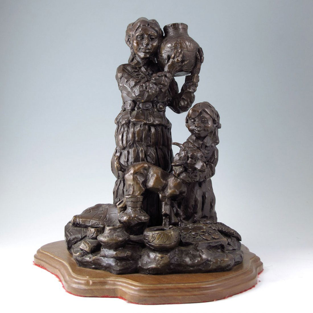 GARY SCHELDT MOTHER AND CHILD BRONZE: SCHILDT, Gary Joseph (Lone Bull), (American, 1938-): Mother and Child with Goat, Bronze, 13" h., 13" w., 11" d., incised signature, dated 1975, affixed to beveled wooden plinth 1/4" h.