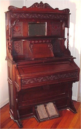 W.W. PUTNAM "American Reed Organ": W.W. PUTNAM "American Reed Organ": Pump action on this true piece of Victoriana. Mirrored backboard. Relief carvings throughout. In good working order. 6'h, 45''w.