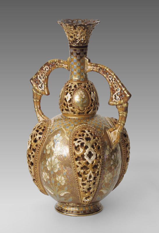 ZSOLNAY RETICULATED DOUBLE WALL VASE 12'' TALL: ZSOLNAY RETICULATED BOTTLE VASE: Ca. 1885-1887, indicated by the incised form number 1827. Double walled with the exterior having reticulated panels. Reticulated handle and rim. Parcel gilt. Approx. 1