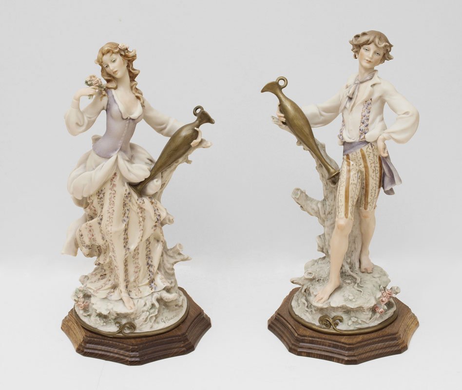 GIUSEPPE ARMANI FIGURAL COUPLE - 2 PC: GIUSEPPE ARMANI FIGURAL COUPLE: Pair of 1986 figurines, each holding a matching ewer, dressed in complementary clothing. Mounted on shaped wooden plinths, overall 14"h.