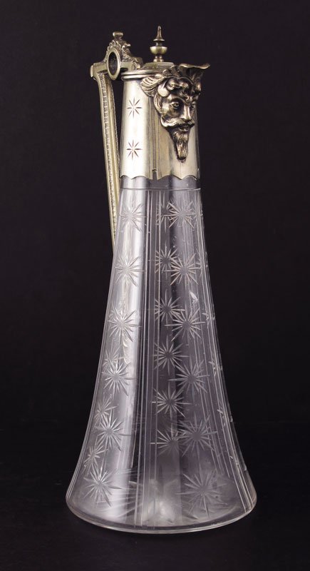 ENGLISH METAL MOUNTED CLARET JUG: ENGLISH METAL MOUNTED CLARET JUG: Metal mounted top and handle with figural masqueron spout, traces of vermeil wash remain. Cut glass base. 11 1/8" x 5 3/4"