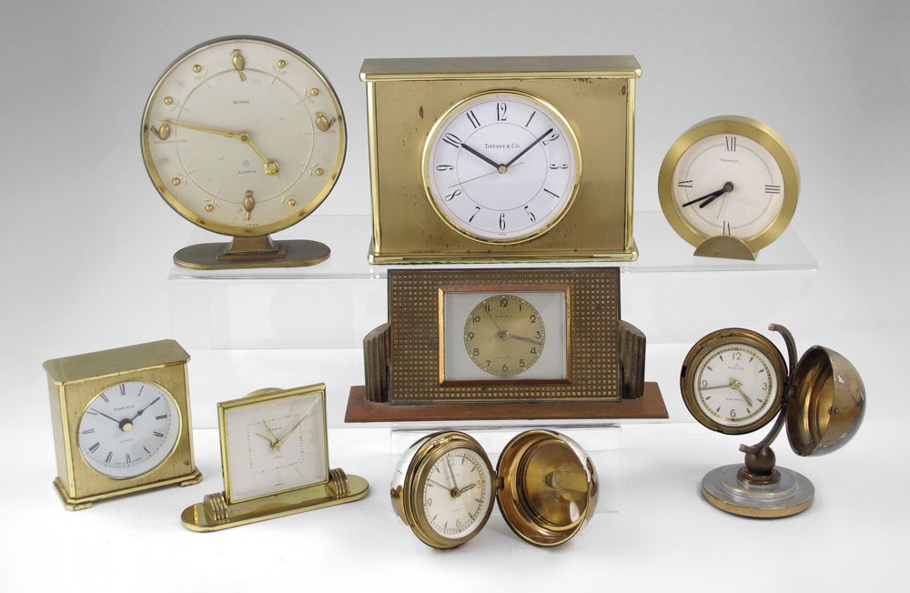 8 PIECE TIFFANY & RENSIE TRAVEL & DESK CLOCKS: 8 PIECE TIFFANY & RENSIE TRAVEL & DESK CLOCKS: To include 1) Tiffany & Co. gold toned desk clock, quartz movement. 5" h. x 6 3/4" x 2 3/8". 2) Tiffany & Co. gold toned circular travel clock with leath