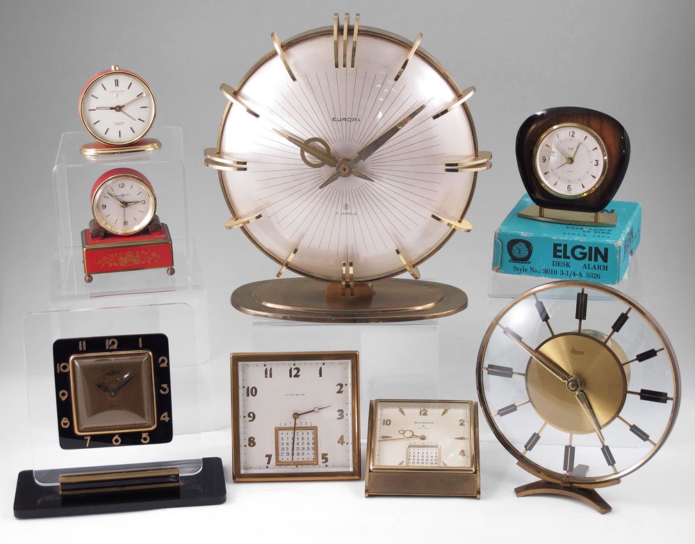 COLLECTION OF 8 TRAVEL & DESK CLOCKS: COLLECTION OF 8 TRAVEL & DESK CLOCKS: To include 1) Looping 15 jewel travel clock with red enamel case. 2 7/8" h. 2) Reuge Music Box desk clock, red finish, 3 1/2" h. 3) Elgin wood case in original bo