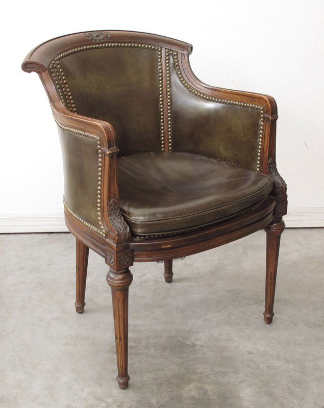 WALNUT BROWN LEATHER LIBRARY CHAIR: WALNUT BROWN LEATHER LIBRARY CHAIR: Carved floral medallion in top rail, shaped arms curve down to accanthus leaves over carved decoration at leg joints. Shaped skirt, reeded tapered legs. Mottled bro