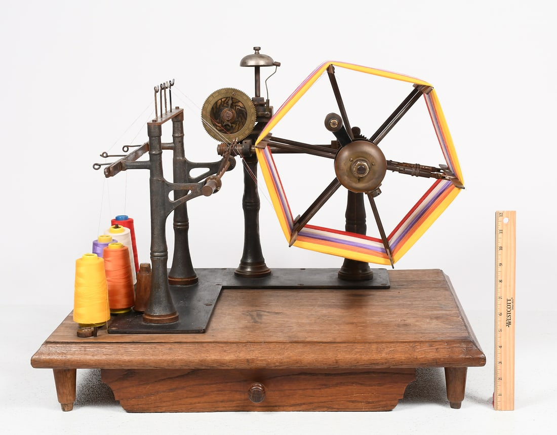 19TH-CENTURY MECHANICAL YARN WINDER: 19TH-CENTURY MECHANICAL YARN WINDER: Antique mechanical countertop skein/yarn winder, cast iron apparatus with handle-turned spoked wheel, bell, and gauge upon wood base, overall measuring approx. 22'