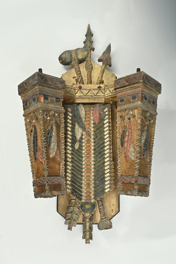 PRAIRIE SCHOOL NATIVE INDIAN MOTIF GAS LIGHT FIXTURE: PRAIRIE SCHOOL NATIVE INDIAN MOTIF GAS LIGHT FIXTURE: A carved and polychrome decorated wood sconce in a Native American motif depicting feathers, beading, leather embroidery, and three primitive tool