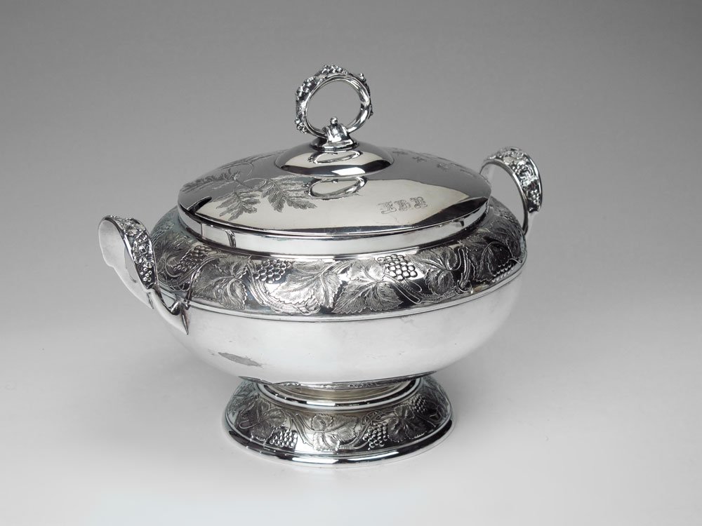 PAIRPOINT SILVERPLATE SOUP TUREEN: PAIRPOINT SILVERPLATE SOUP TUREEN: Embossed grape vine motif, engraved lid. Monogrammed, no ladle. Marked Pairpoint Mfg. Co, Quadruple Plate, 2405, 10. Measures 8 3/4'' h. x 10 1/2''.