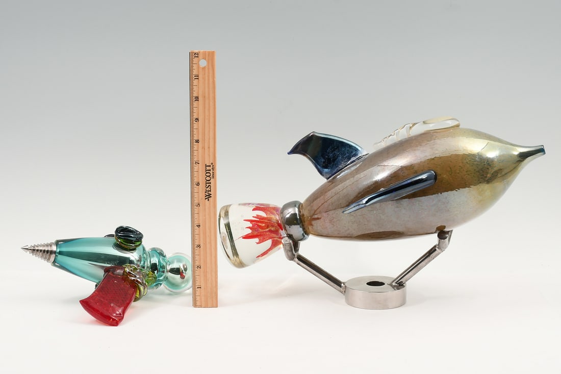 2 JESSE KELLY RETRO COSMIC ART GLASS SCULPTURES: 2 PC. JESSE KELLY RETRO COSMIC ART GLASS SCULPTURES: This Jesse Kelly cosmic, retro-inspired art glass collection includes a ray-gun sculpture and rocket sculpture. Both with iridescent accents. The r