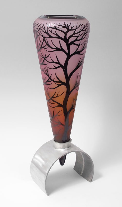 DUNCAN McCLELLAN ART GLASS TREE CONE VASE ON STAND: McCLELLAN, Duncan, (American 1955-): ''Tree Cone'' conical overlay and sand etched vase in a fascinating blend of colors rests in an aluminum stand. The vase is 19 7/8'' tall, the stand measures 9''.