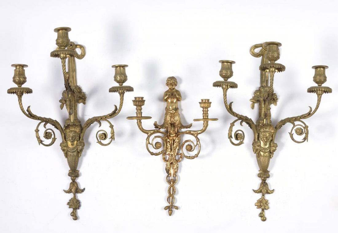 3 PIECE GILT METAL CANDLE SCONCES: 3 PIECE GILT METAL CANDLE SCONCES: To include matched pair foliate decorated 3 light sconces with center masquerons of women. 21 1/2" x 13 3/4" x 9". Sold with a single 2 light with cherub playing flu