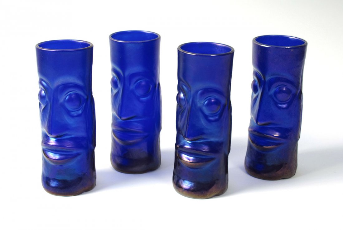 4 PETER VIZZUSI BLUE IRIDESCENT ART GLASS TIKI TU: 4 PETER VIZZUSI BLUE IRIDESCENT ART GLASS TIKI TUMBLERS: Fully hand blown into a bronze mold, the rich iridescence enhances the strong Moai facial features. Signed Magic Sands. Art glass studios locat