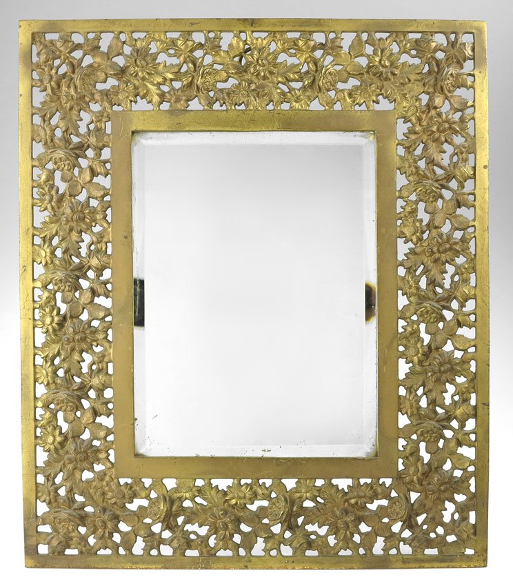 BRADLEY & HUBBARD PATINATED METAL TABLE MIRROR: BRADLEY & HUBBARD PATINATED METAL TABLE MIRROR: Open work foliate motif frame marked B & H, 3576. 16 1/4" x 13 3/4".