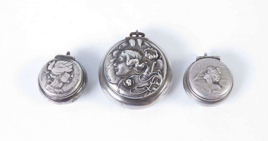 3 PIECE UNGER BROTHERS STERLING PILL BOXES: 3 PIECE UNGER BROTHERS STERLING PILL BOXES: To include 1) Woman with flowers, hinged lid, ring to attachment to chatelaine. 1 1/4'' dia. 2) Smoking woman, hinged lid, 7/8'' dia. 3) Woman profile, hing