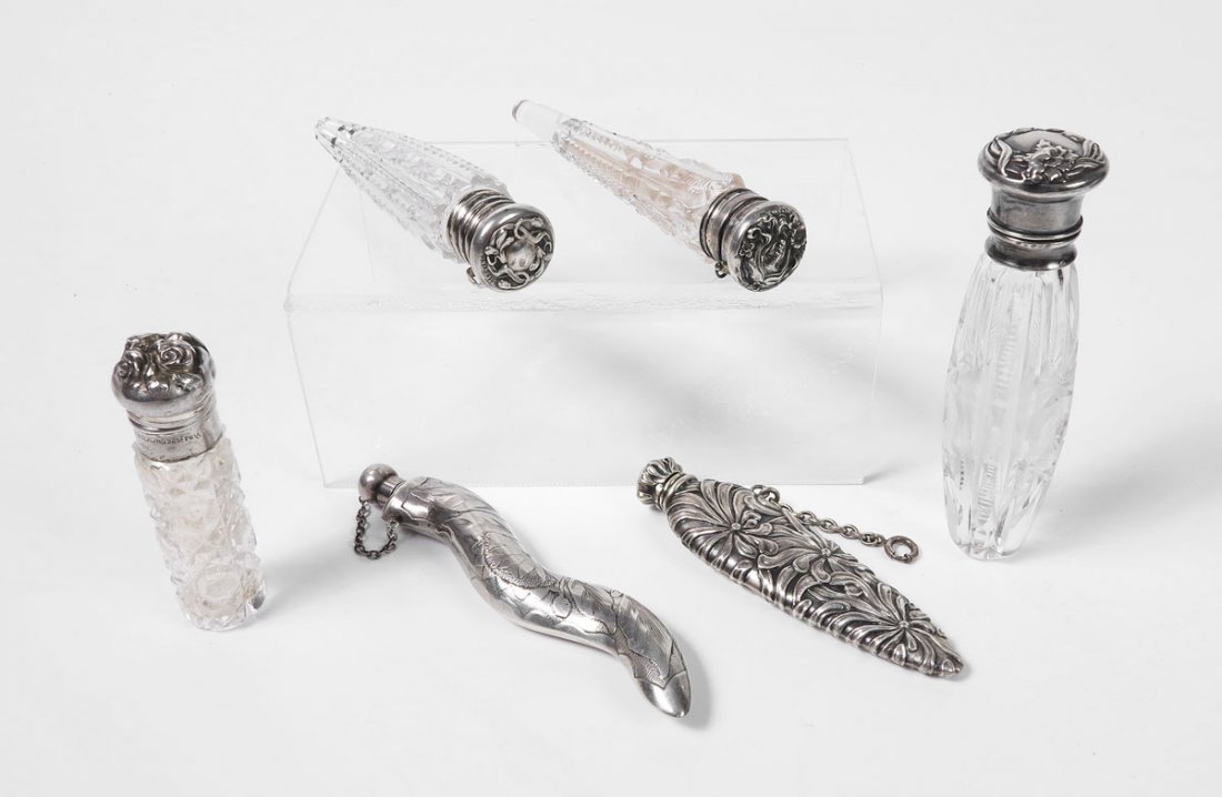 6 STERLING AND MOUNTED LAY DOWN PERFUME BOTTLES: 6 STERLING AND MOUNTED LAY DOWN PERFUME BOTTLES: To include 1) Floral cap with hinged lid, cut glass body. 2) Unger Brothers rose cap with hinged lid, stopper, cut glass body. 3) Woman's face with flo