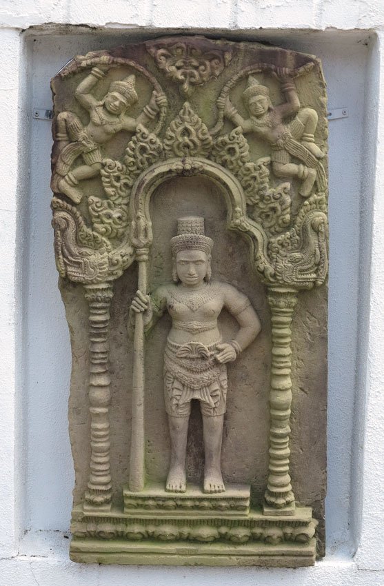 CAMBODIAN CARVED SANDSTONE FRIEZE: CAMBODIAN CARVED SANDSTONE FRIEZE: Frieze having high relief decoration of a standing warrior holding a spear in temple doorway with Gods in upper corners. 35'' high x 18'' wide x 5'' diameter. Actual