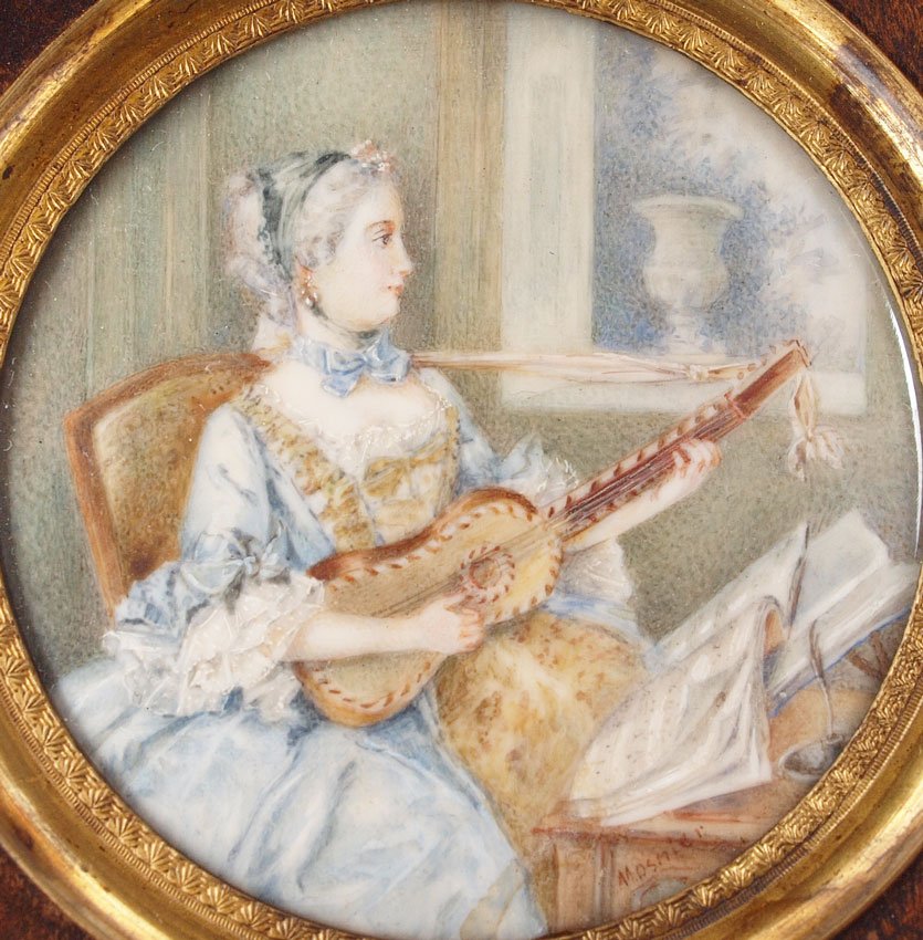 MINIATURE PAINTING ON IVORY WOMAN: MINIATURE PAINTING ON IVORY OF A YOUNG WOMAN PLAYING STRING INSTRUMENT SIGNED MOSHIER?: Circular sight size 2 1/8'' diameter, encased in finger carved wood frame, 4 7/8'' x 4 7/8''.