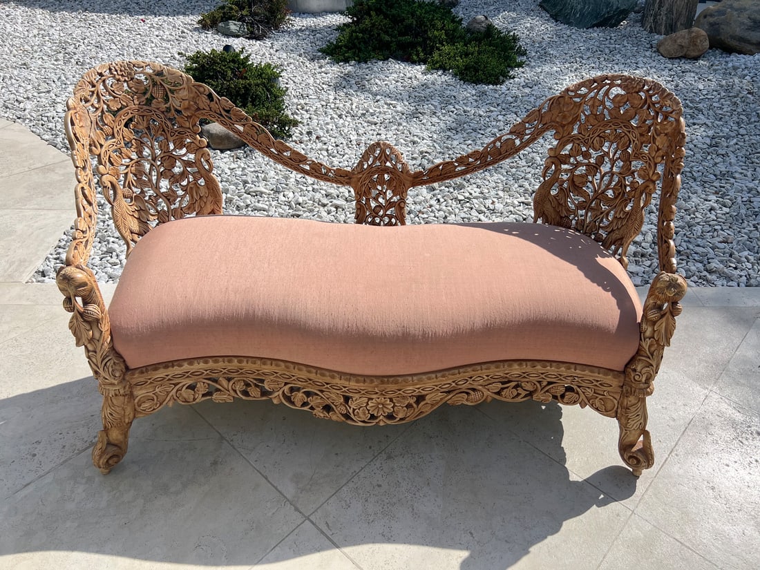 PROFUSELY CARVED & PIERCED BURMESE SOFA: PROFUSELY CARVED & PIERCED BURMESE SOFA: Burmese sofa, having a carved & pierced scrolling foliate motif frame with Figs and Birds. Light pink upholstery. All raised on scrolled feet. Approx. 34" h x