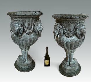 A MAJESTIC PAIR OF BRONZE LION HANDLED URNS