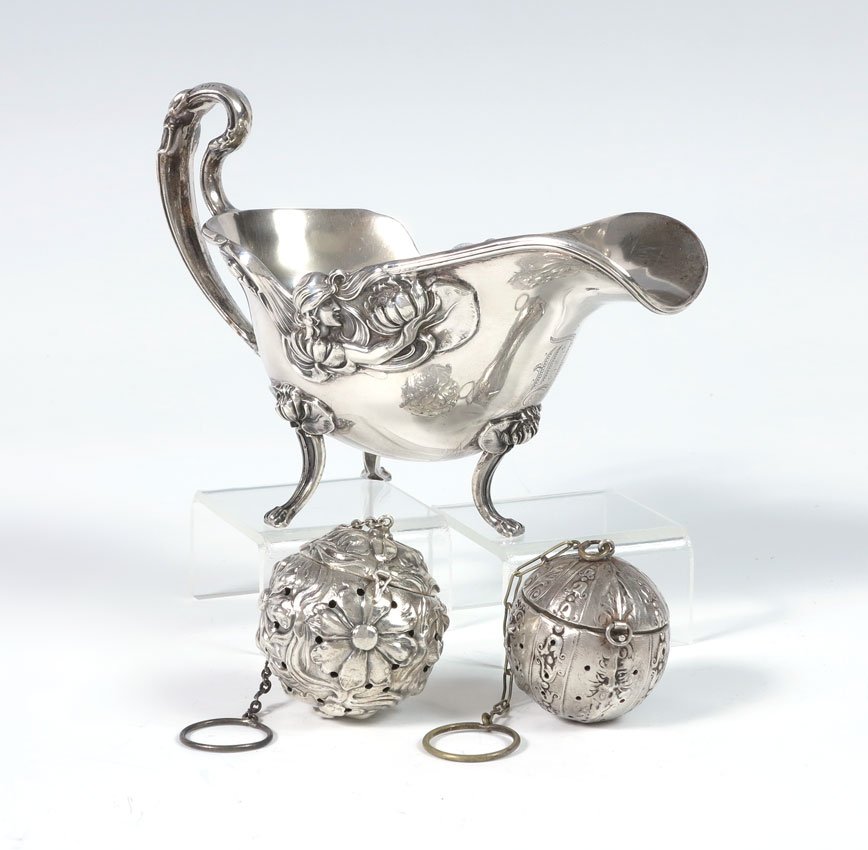ART NOUVEAU STERLING GRAVY BOAT & TEA BALLS: ART NOUVEAU STERLING GRAVY BOAT & TEA BALLS: To include 1) Unger Brothers Gravy boat with applied woman in profile holding a water lily on each side, 4'' h. x 6'' x 2 7/8''. 2) Webster floral tea ball