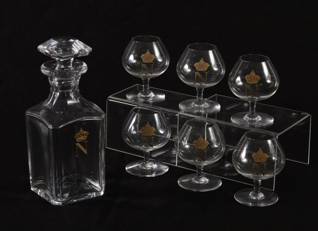 BACCARAT DECANTER & BRANDY STEMS: BACCARAT FRENCH CRYSTAL DECANTER & 6 BRANDY STEMS: Each piece with a gold crown and N embossed decoration. The glasses are signed Baccarat. Decanter with stopper measures 8" tall, the glasses, 3 3/4".